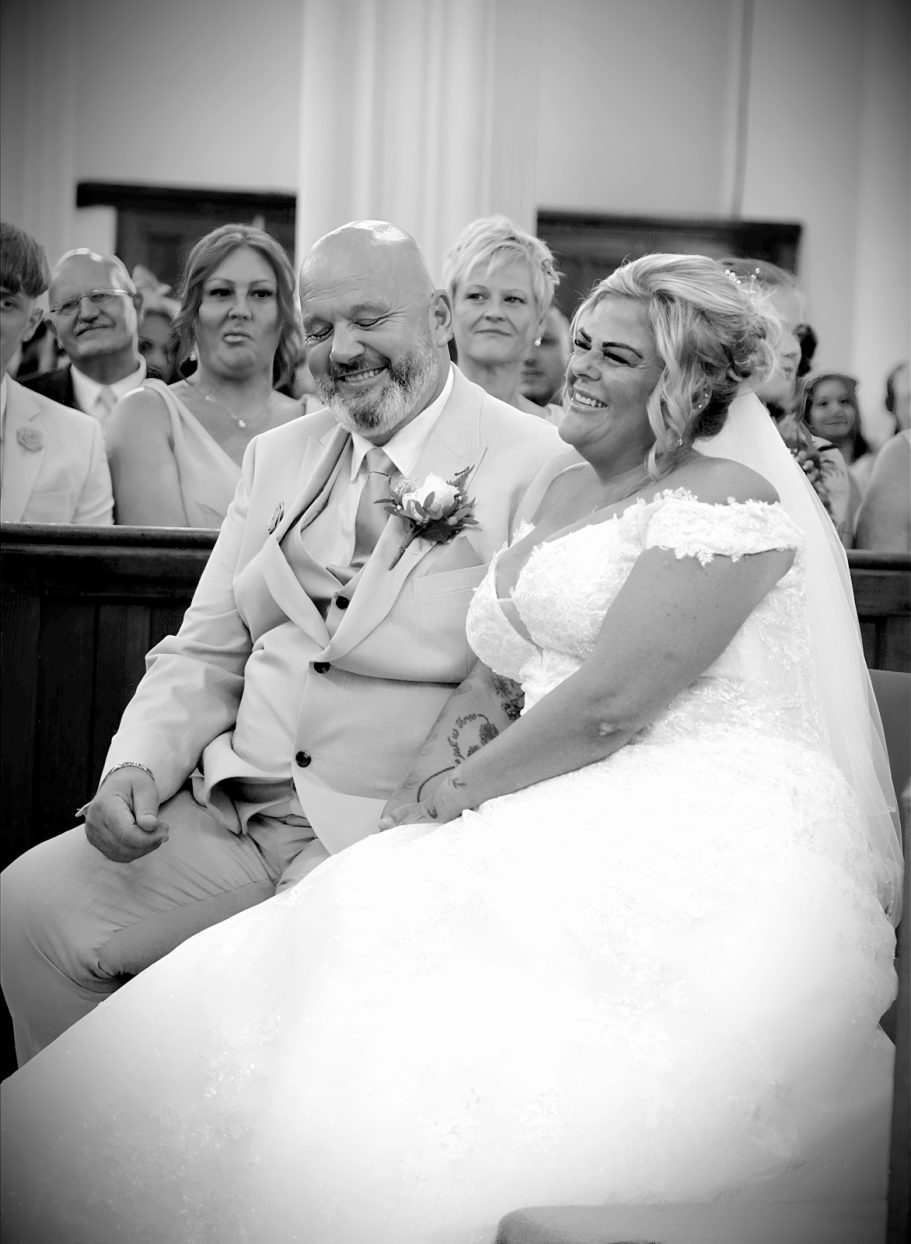 Bride & Groom laughing during ceremony, All Saints Church Dudley Photographed by Wolverhampton wedding photographer Sarah Ratcliffe