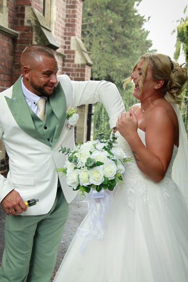 Groom removing confetti from brides dress, Thomas Robinson Building Stourbridge