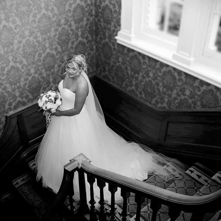 Bride on stairs at Brockencote Hall Hotel, Stourbridge Photographed by Wolverhampton wedding photographer Sarah Ratcliffe